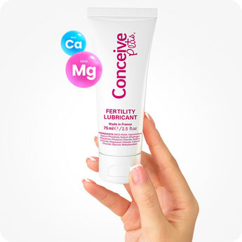 For Conceive Plus Fertility Lubricant Duo Bundle (75ml and 8 Applicators), showing 75ml fertility lubricant tube held upright between fingers, with floating Ca⁺ and Mg⁺ ion graphics on side, emphasizing product's mineral-enriched, sperm-friendly formula.