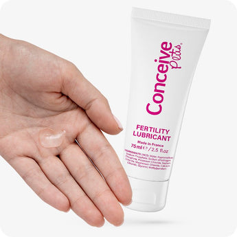 For Conceive Plus Fertility Lubricant Duo Bundle (75ml and 8 Applicators), image of 75ml fertility lubricant tube shown next to an open palm with a small amount of clear gel dispensed, illustrating product texture and real-use application for couples trying to conceive.