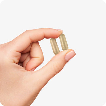 For Conceive Plus Maximum Fertility Bundle, image of women's ovulation support capsules in light beige tone, held delicately between fingers, displaying smooth texture and average capsule size ideal for daily women’s fertility support use.