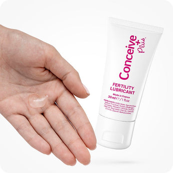 For Conceive Plus Maximum Fertility Bundle, image showing 30ml fertility lubricant tube alongside a close-up of a hand with a clear dollop of gel, emphasizing texture, consistency, and user-friendly application for conception support.