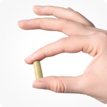 Conceive Plus Morning Sickness Relief capsule held between thumb and index finger, showing compact capsule size and smooth texture against a white background, emphasizing easy swallowing and daily use during pregnancy.