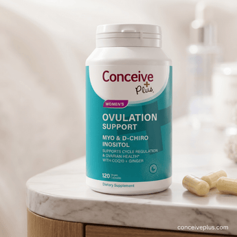 Supplement bottle labeled 'Conceive Plus Women's Ovulation Support' on a marble surface.