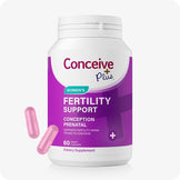 Conceive Plus Women's Fertility Support bottle featuring a white and purple label with turquoise accents, displaying “Conception Prenatal” and “60 Vegan Capsules,” with two pink capsules placed in front to show supplement form.