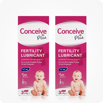 For Conceive Plus Women's Fertility Support and Fertility Lubricant Bundle, a twin-pack of 3x4g pre-filled fertility lubricant applicator boxes, each featuring bright pink and white packaging with a smiling baby image, fertility support claims, and icons for pH balance and calcium-magnesium content, arranged on a white background.